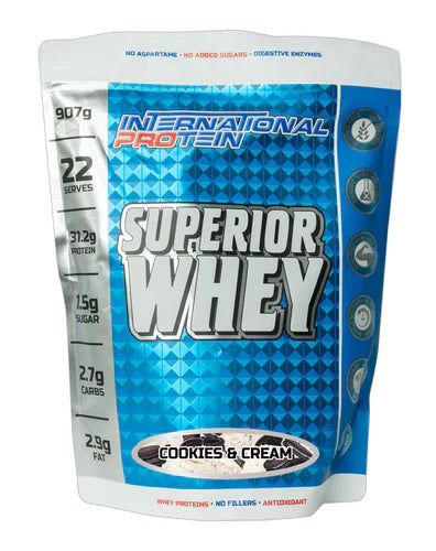 International Protein Superior Whey in Cookies and Cream flavor, 907g container with a scoop of protein powder on a clean surface.